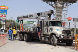 Grúa Titán levantando material en obra de construcción.