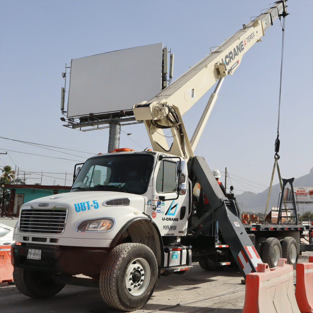 Grúa Titan montada en camión Freightliner operando en ciudad.