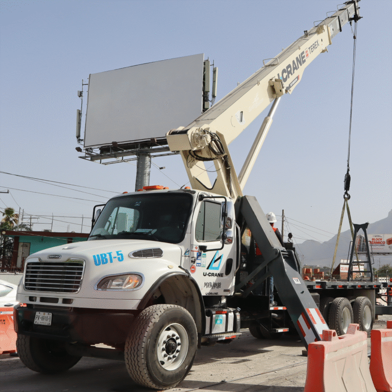 Grúa Titan montada en camión Freightliner operando en ciudad.